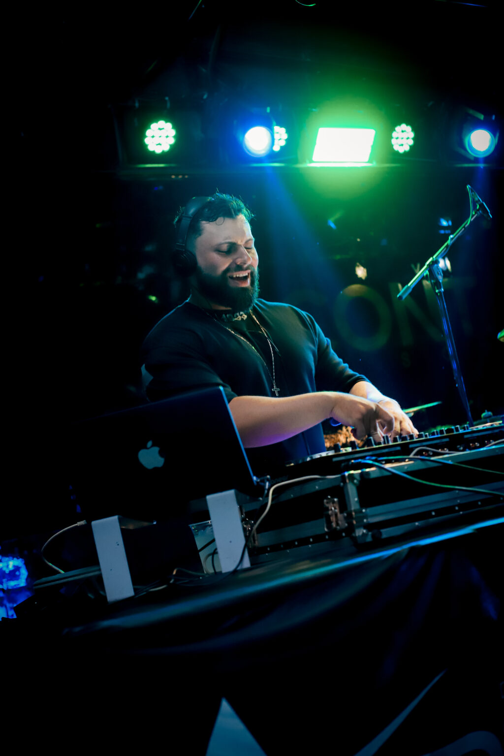 DJ Andrez tocando e operando a mesa de som em um evento real